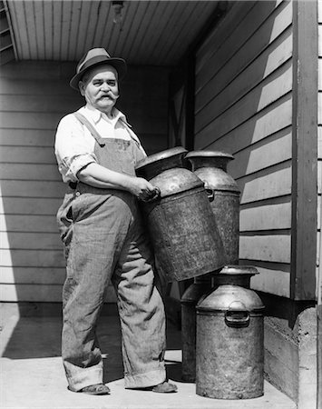 1930s MATURE ELDERLY MAN DAIRY FARMER HOLDING CARRYING METAL MILK CANS CANISTERS FARM Foto de stock - Con derechos protegidos, Código: 846-02792408