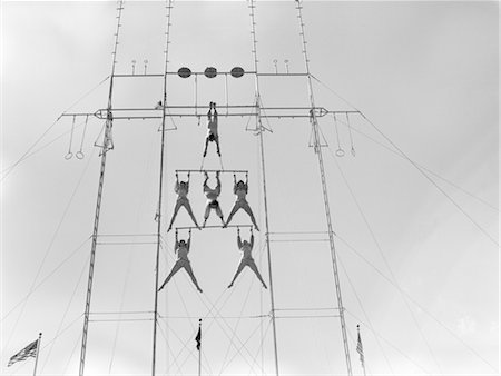 1950s SIX CIRCUS PERFORMERS BALANCED ON HIGH TRAPEZE Fotografie stock - Rights-Managed, Codice: 846-02792482