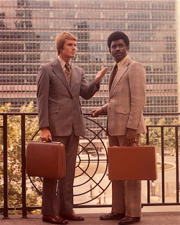 suits for men in old fashion - 1960s TWO BUSINESSMEN SALESMEN ONE AFRICAN AMERICAN CARRYING ATTACHÉ CASES STANDING IN OFFICE COMPLEX Stock Photo - Rights-Managed, Code: 846-02792642