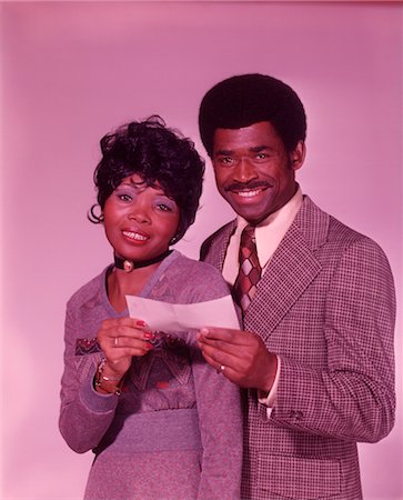 COUPLE AFRO-AMÉRICAIN DES ANNÉES 1970, SOURIANT HOLDING VÉRIFIER Photographie de stock - Rights-Managed, Code: 846-02792678