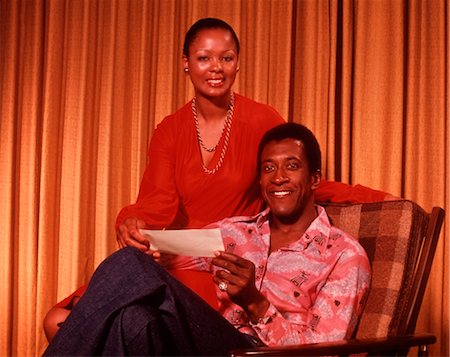 COUPLE AFRO-AMÉRICAIN DES ANNÉES 1970, SOURIANT HOLDING VÉRIFIER Photographie de stock - Rights-Managed, Code: 846-02792681