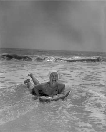 1950s LAUGHING WOMAN ON INFLATED RAFT IN SURF Foto de stock - Con derechos protegidos, Código: 846-02792708