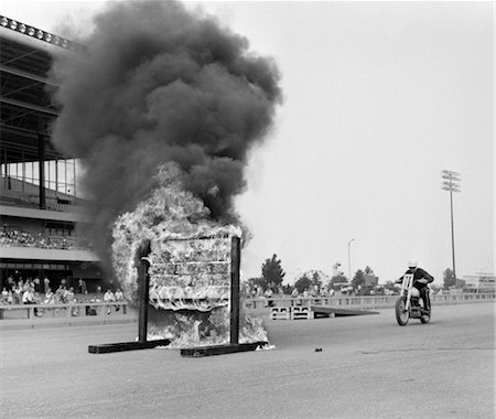 1960s DAREDEVIL ON MOTORCYCLE APPROACHING WALL OF FIRE Foto de stock - Con derechos protegidos, Código: 846-02792717
