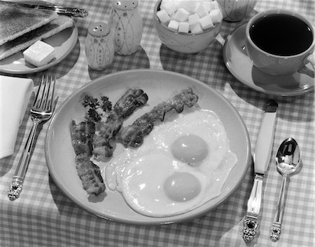 simsearch:846-03164324,k - 1950s BREAKFAST PLATE OF BACON & FRIED EGGS & COFFEE SUGAR BOWL TOAST SALT & PEPPER SHAKERS ON CHECKERED TABLECLOTH Stock Photo - Rights-Managed, Code: 846-02792835