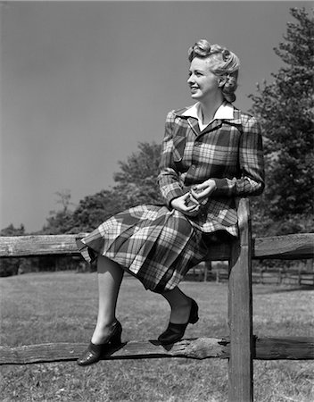 1940s FULL LENGTH PORTRAIT OF BLOND WOMAN SITTING ON A WOODEN FENCE WEARING PLAID TARTAN SUIT Foto de stock - Con derechos protegidos, Código: 846-02792964