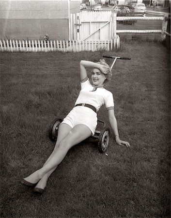 short - 1950s EXHAUSTED WOMAN WEARING WHITE SHORT SHORTS LYING ON TOP OF A PUSH LAWN MOWER LOOKING AT CAMERA Stock Photo - Rights-Managed, Code: 846-02792994