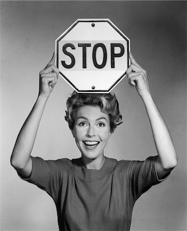 einstellen - 1960s SMILING WOMAN HOLDING STOP SIGN ABOVE HER HEAD Foto de stock - Con derechos protegidos, Código: 846-02793061