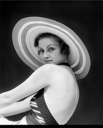 1930s WOMAN WEARING A STRIPED HALTER TOP & WIDE BRIM STRIPED STRAW HAT LOOKING OVER SHOULDER Stock Photo - Rights-Managed, Code: 846-02793072