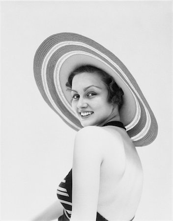 1930s WOMAN WEARING STRIPED HALTER TOP AND VERY WIDE BRIM STRAW HAT LOOKING AT CAMERA OVER SHOULDER Stock Photo - Rights-Managed, Code: 846-02793073