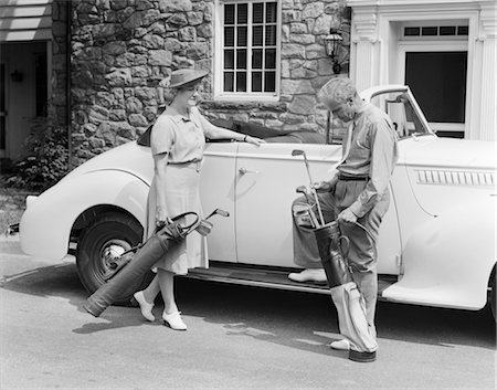 1930s 1940s SENIOR COUPLE PUTTING GOLF CLUBS IN CONVERTIBLE CAR BY STONE HOUSE Stock Photo - Rights-Managed, Code: 846-02793084