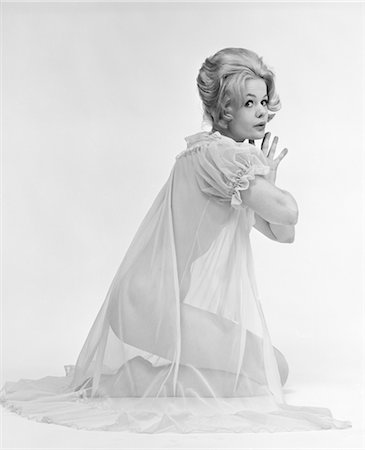 sheer - 1960s PROFILE PORTRAIT OF BLOND WOMAN IN SHEER NIGHTGOWN KNEELING DOWN WITH HANDS PRESSED TOGETHER LOOKING AT CAMERA Foto de stock - Con derechos protegidos, Código: 846-02793089