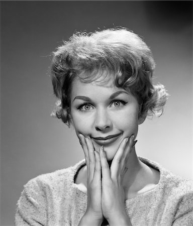 1950s 1960s HAPPY BEMUSED WOMAN FACIAL EXPRESSION BOTH HANDS TO CHIN SMILE Stock Photo - Rights-Managed, Code: 846-02793126