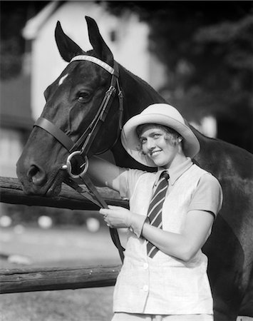 simsearch:846-02795874,k - 1930s WOMAN STANDING BESIDE HORSE HOLDING REINS SMILING WEARING FASHIONABLE HAT STRIPED NECK TIE GLOVES LINEN VEST LOOKING AT CAMERA Stock Photo - Rights-Managed, Code: 846-02793218