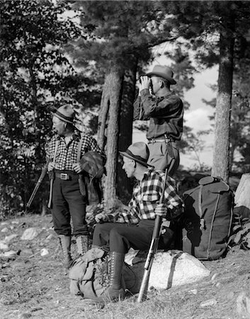 1930s 1940s 3 MEN HUNTING WITH RIFLES BACKPACKS & BINOCULARS WEARING HATS & PLAID SHIRTS AT THE LAKE OF THE WOODS ONTARIO Stock Photo - Rights-Managed, Code: 846-02793211