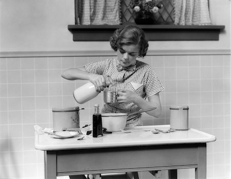 1930s TEENAGE GIRL IN KITCHEN POURING MILK IN MEASURING CUP FOR BAKING Foto de stock - Con derechos protegidos, Código: 846-02793253