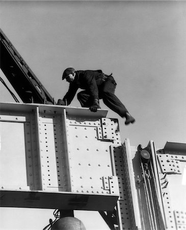 simsearch:846-02793337,k - 1930s CONSTRUCTION WORKER MAN ON STEEL GIRDER CLIMBING WEARING CAP Foto de stock - Con derechos protegidos, Código: 846-02793337