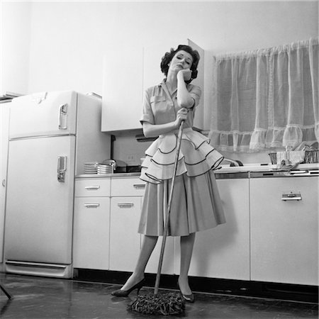 retro housewife kitchen - 1950s BORED WOMAN HOUSEWIFE WEARING APRON LEANING ON MOP ON KITCHEN FLOOR Stock Photo - Rights-Managed, Code: 846-02793332