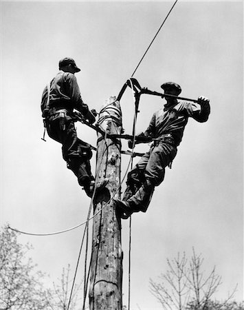 1930s 1940s TWO MEN WORKING ON ELECTRICAL POWER POLE CUTTING WIRE Stock Photo - Rights-Managed, Code: 846-02793348