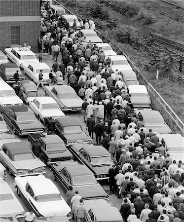 simsearch:846-02793389,k - 1960s OVERHEAD OF FACTORY WORKERS IN CROWDED PARKING LOT GETTING OUT OF CARS & WALKING TOWARD BUILDING TO WORK Stock Photo - Rights-Managed, Code: 846-02793400