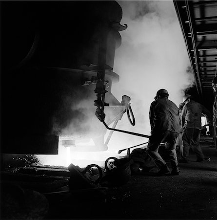 fornace - MEN WORKING IN STEEL MILL BLAST FURNACE MOLTEN METAL HOT HEAT HARD HAT WORK ALAN WOOD STEEL Fotografie stock - Rights-Managed, Codice: 846-02793419