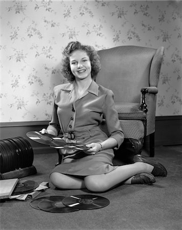 1940s YOUNG WOMAN TEEN SITTING ON FLOOR BY CHAIR HOLDING SORTING 78 RPM PHONOGRAPH RECORDS Stock Photo - Rights-Managed, Code: 846-02793453