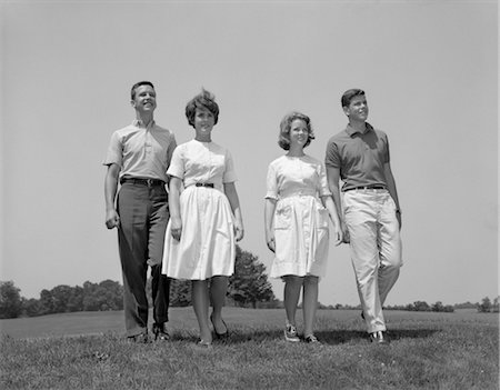 1960s TWO TEENAGE COUPLES BOYS GIRLS FULL LENGTH WALKING THROUGH FIELD TOWARDS CAMERA Foto de stock - Con derechos protegidos, Código: 846-02793469