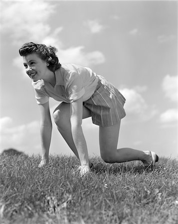 simsearch:846-02795744,k - 1940s SMILING YOUNG TEEN WOMAN KNEELING IN GRASS IN TRACK RACE READY STARTING POSITION Foto de stock - Con derechos protegidos, Código: 846-02793559