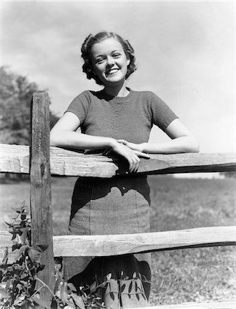 1940s PORTRAIT SMILING YOUNG GIRL WOMAN LEANING ON WOODEN FENCE Stock Photo - Rights-Managed, Code: 846-02793576