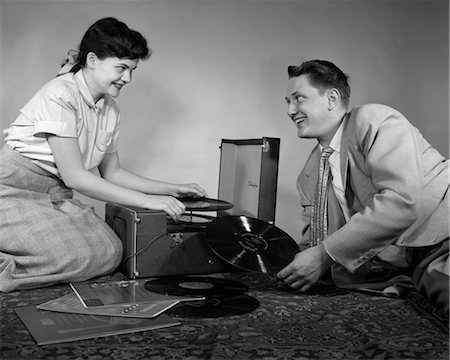 simsearch:846-05646579,k - ANNÉES 1950 TEEN COUPLE GARÇON FILLE ASSISE ÉTAGE JOUER DES ENREGISTREMENTS SUR PHONOGRAPHE PORTATIF Photographie de stock - Rights-Managed, Code: 846-02793590