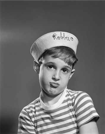 1950s PORTRAIT SAD POUTING BOY WEARING SAILOR HAT MONOGRAMMED WITH NAME ROBBIE Foto de stock - Con derechos protegidos, Código: 846-02793644