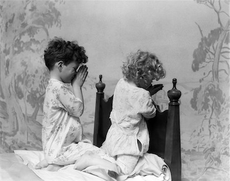 domenica mattina - 1930s BOY GIRL AT END OF BED IN PAJAMAS SAYING PRAYERS PRAYING Fotografie stock - Rights-Managed, Codice: 846-02793642