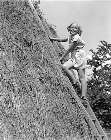 1940s SMILING BLOND GIRL CLIMBING LADDER LEANING AGAINST TALL HAY STACK Stock Photo - Rights-Managed, Code: 846-02793666