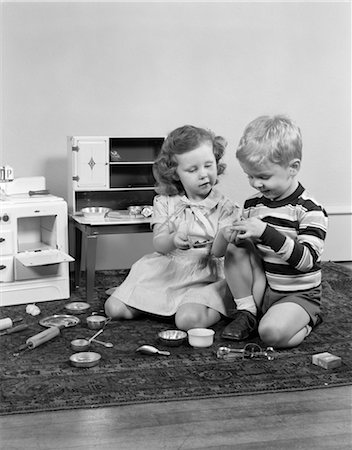 1950s BOY & GIRL PLAYING HOUSE WITH TOY STOVE & PANTRY WITH POTS PANS DISHES AND COOKING UTENSILS Stock Photo - Rights-Managed, Code: 846-02793672