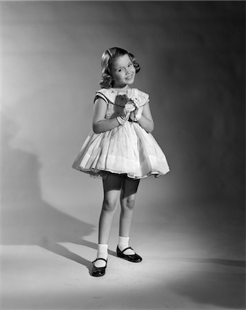 1950s PRETTY POSING GIRL SMILING FANCY DRESS WHITE GLOVES PATENT LEATHER SHOES FULL LENGTH SEAMLESS Foto de stock - Con derechos protegidos, Código: 846-02793738
