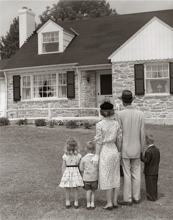 1950s FAMILY OF FIVE WITH BACKS TO CAMERA ON LAWN LOOKING AT FIELDSTONE HOUSE Foto de stock - Con derechos protegidos, Código: 846-02793754