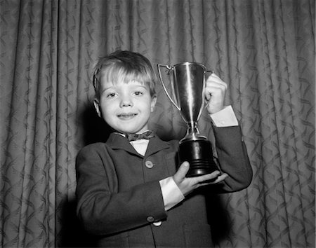 premier - 1950s SMILING PROUD BOY HOLDING UP TROPHY AWARD Foto de stock - Con derechos protegidos, Código: 846-02793767