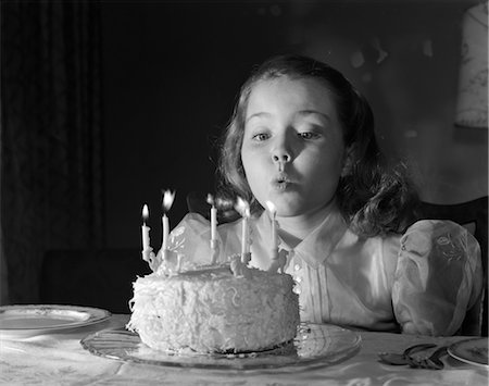 ANNÉES 1950 MAKE A WISH PETITE FILLE DE CINQ ANS D'EXISTENCE DE SOUFFLER LES BOUGIES DU GÂTEAU D'ANNIVERSAIRE Photographie de stock - Rights-Managed, Code: 846-02793774