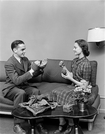 faire la cour - ANNÉES 1940 PARADES NUPTIALES COUPLE ADOLESCENT ASSIS SUR UN CANAPÉ DÉROULEMENT D'UNE PELOTE DE LAINE LAINE À TRICOTER Photographie de stock - Rights-Managed, Code: 846-02793779