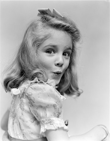 1940s PORTRAIT YOUNG GIRL TURNED TO ONE SIDE LOOKING AT CAMERA WITH FUNNY FACIAL EXPRESSION Stock Photo - Rights-Managed, Code: 846-02793815