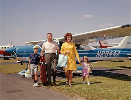 1960s FAMILY OF 4 WALKING FROM PRIVATE PLANE ACROSS TARMAC TRAVEL TRIP LUGGAGE MOTHER FATHER SON DAUGHTER Stock Photo - Rights-Managed, Code: 846-02793851