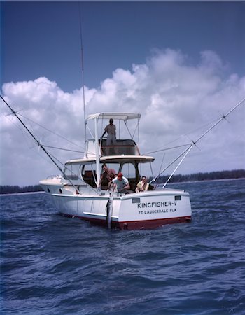 deep sea - 1950s CHARTER FISHING BOAT MAN LIFTING CATCH INTO BOAT WATER BLUE SKY CLOUDS KINGFISHER V FT. LAUDERDALE FL SPORT Stock Photo - Rights-Managed, Code: 846-02793886