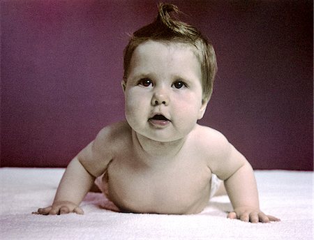 1940s 1950s BABY RAISING HEAD UP PUSHING WITH ARMS LIKE PUSH UP EXERCISE Stock Photo - Rights-Managed, Code: 846-02793947
