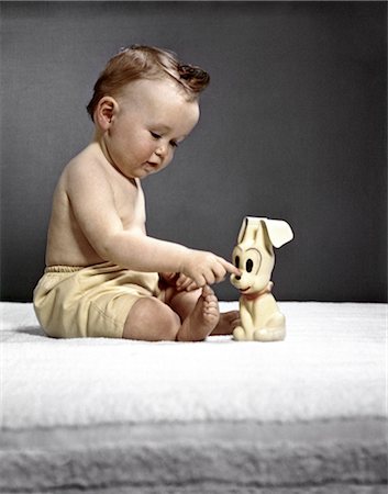 1940s 1950s BABY SITTING TOUCHING TOY DOG Stock Photo - Rights-Managed, Code: 846-02793949