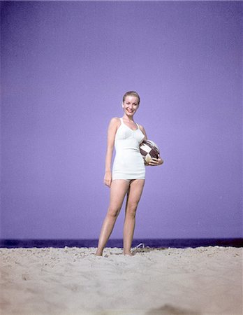 1950s FULL LENGTH PORTRAIT WOMAN WHITE BATHING SUIT SWIMWEAR STANDING ON SAND HOLDING BEACH BALL FASHION Foto de stock - Con derechos protegidos, Código: 846-02793979