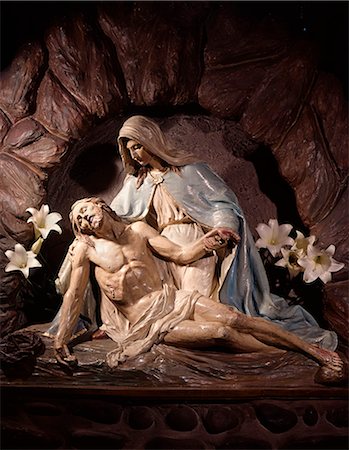 A PIETA STATUE OF MARY MOTHER HOLDING DEAD BODY OF JESUS CHRIST IN HER LAP WITH WHITE LILIES Foto de stock - Con derechos protegidos, Código: 846-03164199