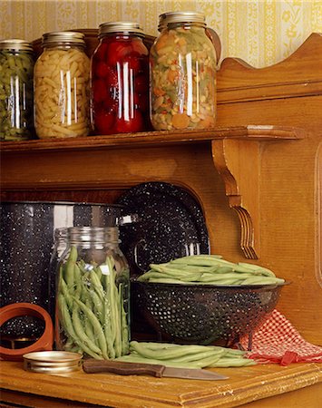 VINTAGE WOODEN KITCHEN COUNTER WITH GREEN BEANS IN COLANDER AND JARS OF CANNED VEGETABLES Stock Photo - Rights-Managed, Code: 846-03164237