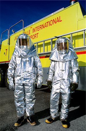TWO PEOPLE IN SILVER FIRE FIGHTING SUITS Fotografie stock - Rights-Managed, Codice: 846-03164333
