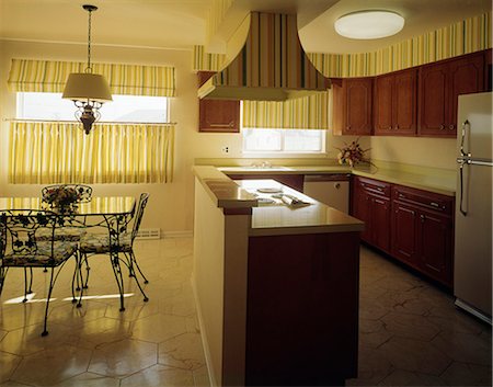 simsearch:846-03164687,k - 1970s KITCHEN AND DINING AREA WITH YELLOW STRIPED CURTAINS WALLPAPER AND DARK WOODEN CABINETS Foto de stock - Direito Controlado, Número: 846-03164688