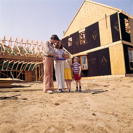 site (lieu) - ANNÉES 1970 FAMILLE PÈRE MÈRE GARÇON FILLE MAISON NEUVE CONSTRUCTION SITE HOMME FEMME ENFANTS COUPLE Photographie de stock - Rights-Managed, Code: 846-03164860