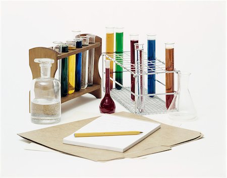 1970s STILL LIFE OF TEST TUBES BOTTLES FILLED WITH COLORFUL LIQUIDS AND FOLDER PAPER TABLET AND PENCIL Stock Photo - Rights-Managed, Code: 846-03164926